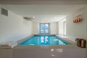 A swimming pool with a view of mountains, a towel stack, and a copper bucket. - Sant' Anna Deluxe (Menaggio)