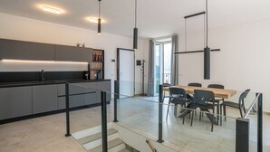 Et moderne køkken med spiseområde, trappe og udsigt til det fri.