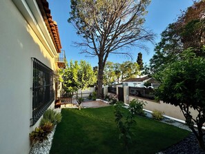 A residential area with a well-maintained lawn, a large tree, and a house with a tiled roof and a brick wall. - Stunning villa close to Marbella towncenter (Marbella)