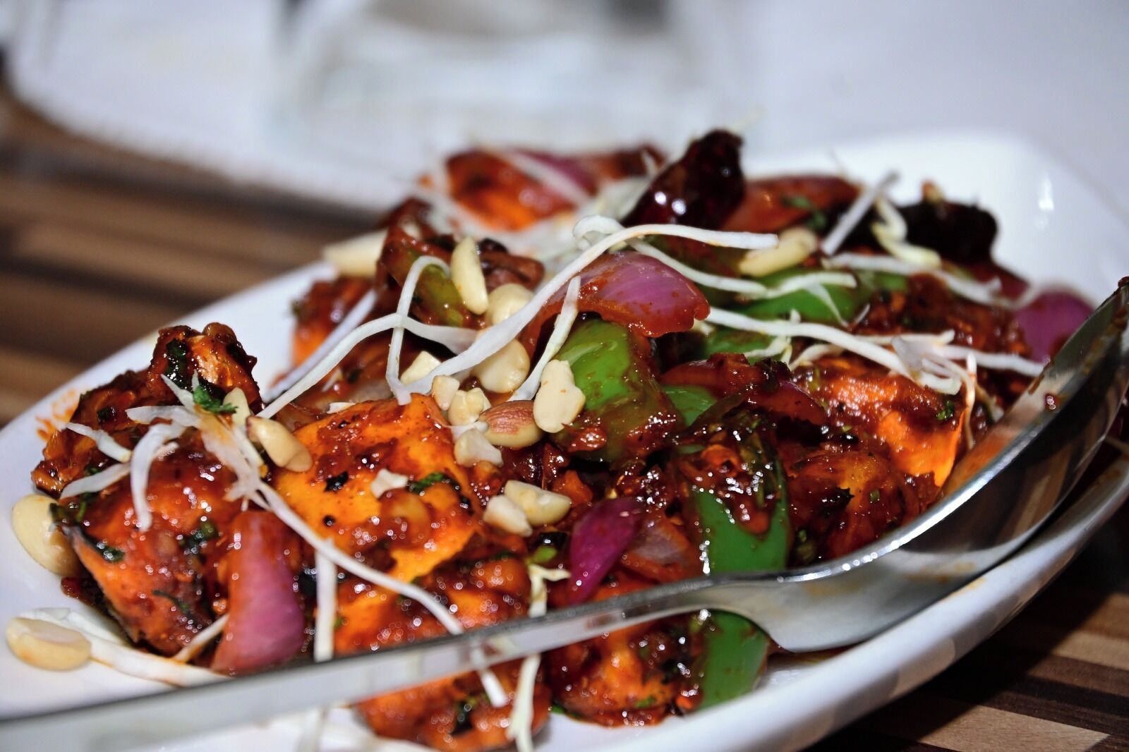 A dish with chicken, vegetables, and sprouts on a white plate.