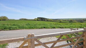 A rural landscape with a gravel path leading to a wooden gate. - Little Blagdon (Holsworthy)