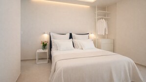 Egy modern hálószoba, melyben egy nagy ágy, éjjeliszekrények, egy lámpás asztal és egy beépített szekrény található.