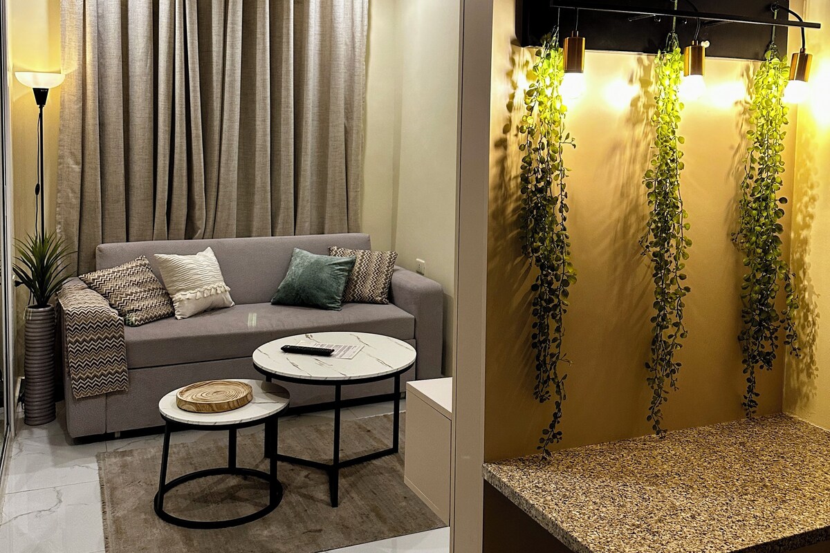 A modern living room with a sofa, coffee table, and a wall-mounted light fixture.
