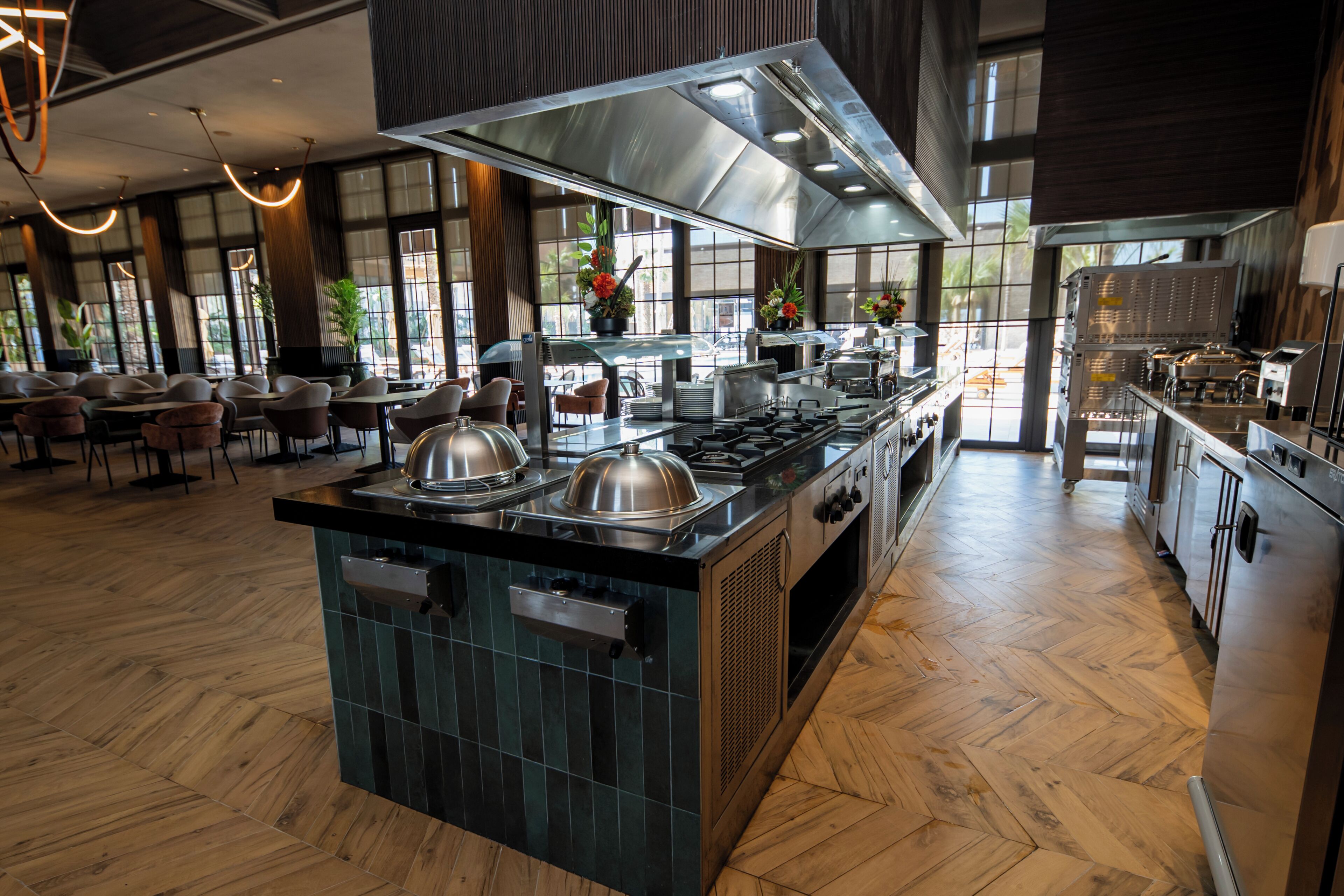 A modern kitchen with a central island, stainless steel appliances, and a view of the dining area.