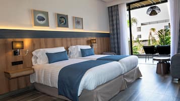 Une chambre d’hôtel comprenant un lit, des tables de chevet, une chaise, une petite table et une vue sur l’extérieur.