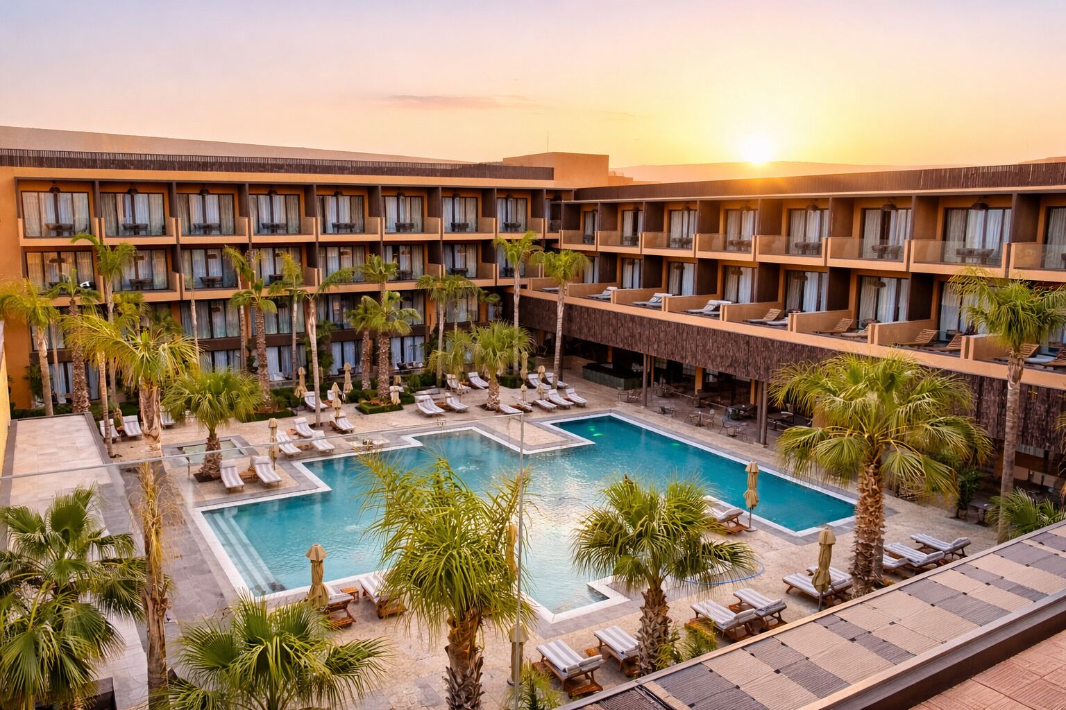 Un hotel con piscina, varios balcones y palmeras.