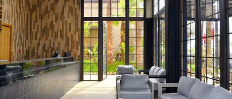 A reception area with a counter, seating area, and large windows.