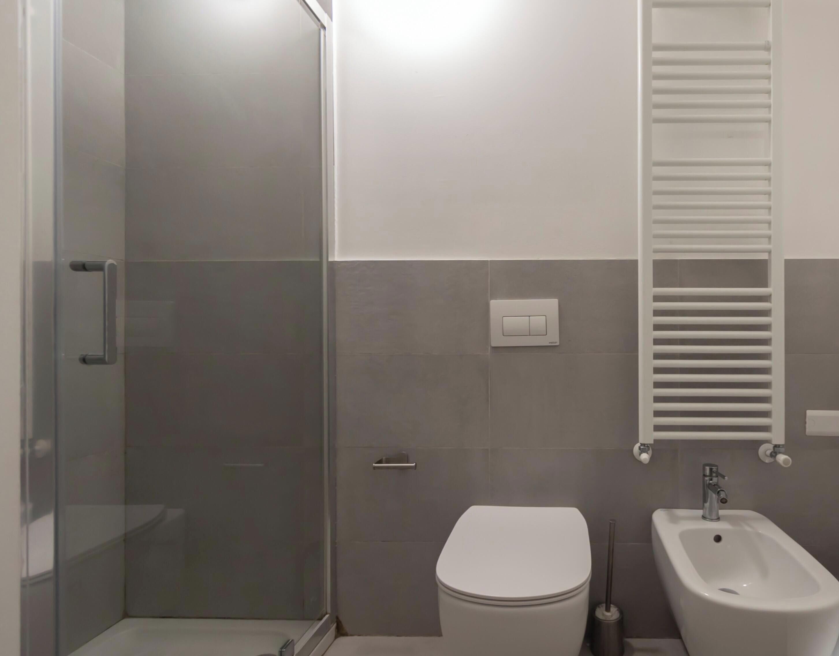 Appartement | Badkamer | Een douche, handdoeken, toiletpapier