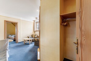 Ein Hotelzimmer mit einem Bett, einer Couch, einem kleinen Tisch und einem Holzschrank.