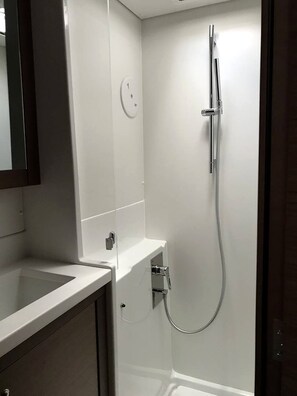 A bathroom with a shower, a sink, and a mirror.