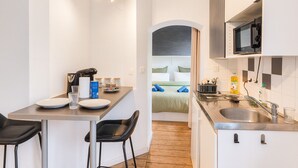 A compact kitchen with a dining area, a microwave, and a sink.