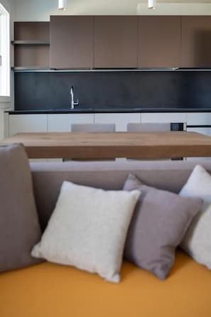 Una cocina moderna con una mesa de madera y un sofá con cojines.