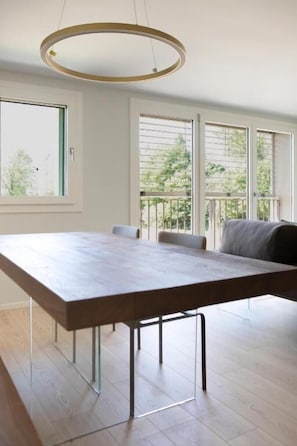 A modern dining area with a long table, chairs, and a circular ceiling light. - Ca' Allegra  (Mogliano Veneto)