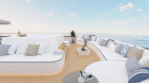 A modern outdoor deck with white sofas, a small table, and a potted plant. - Sun-Kissed Sailing Adventure in Split, Croatia (Split)
