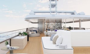 A modern outdoor deck with seating areas, a bar, and a dining setup. - Sun-Kissed Sailing Adventure in Split, Croatia (Split)
