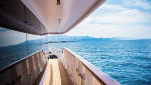 Ein Bootsdeck mit Blick auf das Meer und ferne Berge.