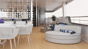 A modern interior with a round seating area, white chairs, and a wooden deck. - Sun-Kissed Sailing Adventure in Split, Croatia (Split)