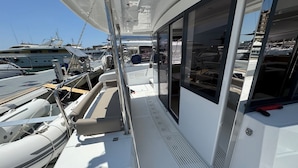 Un pont de yacht doté d’un espace salon, d’une fenêtre et d’une rambarde.