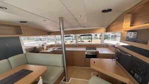 Une cuisine compacte équipée d’un évier, d’un four et d’un petit coin repas avec une table et des bancs.
