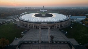 A large circular building with a central open space, surrounded by a paved area with trees and a clear sky. - Garner Hotel Berlin Messe by IHG (Berlin)