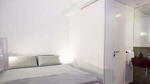 A bedroom with a bed, a wardrobe, and a bathroom with a sink. - GuestHost - A practical and welcoming 50 square meters open-plan loft, perfect for two people, located on the ground floor of an elegant building with a courtyard.The property is located in the Prati district, one of Rome's most charming areas: our guest (Rome)