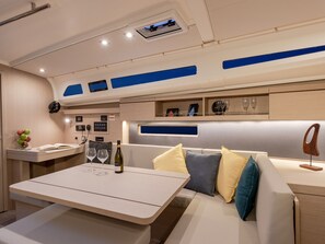 Ein modernes Interieur mit einer Sitzecke, einem Tisch mit Flasche und Gläsern sowie einer Bedienkonsole.