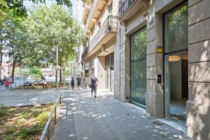 A pedestrian pathway adjacent to a building with large windows and a visible entrance. - Bonavista Apartments - Tamarit (Barcelona)