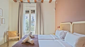 Une chambre d’hôtel avec un lit, une chaise et une fenêtre avec des rideaux.