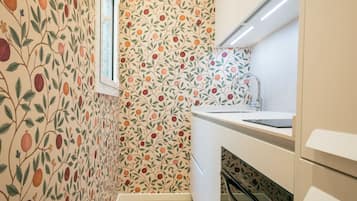 Une cuisine avec un papier peint à motifs, une fenêtre et un évier moderne.