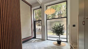 Un interior moderno con un amplio ventanal, una lámpara colgante y una planta en maceta.