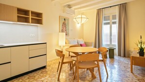 A compact living space with a kitchenette, dining area, and a sofa set.