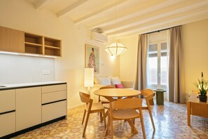 A compact living space with a kitchenette, dining area, and a sofa set.