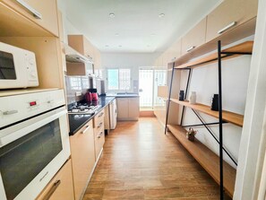 Une cuisine moderne avec des meubles en bois, une cuisinière et un four à micro-ondes.