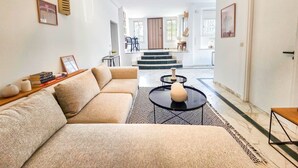 A modern living room with a sectional sofa, a round coffee table, and a patterned rug.