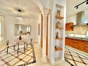A modern kitchen with wooden cabinets, a stainless steel range hood, and a granite countertop. - GOLDEN TULIP APT SPACIEUX AVEC DEUX TERRASSES (La Marsa)