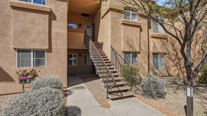 A multi-story building with a central staircase, outdoor seating area with flowers, and a tree. - 2nd floor includes many personal touches and upgrades making a Perfect rental (Tucson)