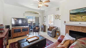 A living room with a television, leather sofa, and a fireplace. - 2nd floor includes many personal touches and upgrades making a Perfect rental (Tucson)