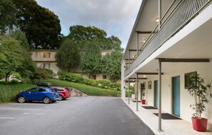 En modern byggnad med en överbyggd gångväg och en parkeringsplats med plats för två bilar.