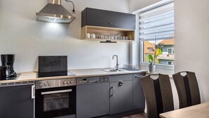 Una cocina moderna con horno empotrado, lavavajillas y campana extractora de acero inoxidable.