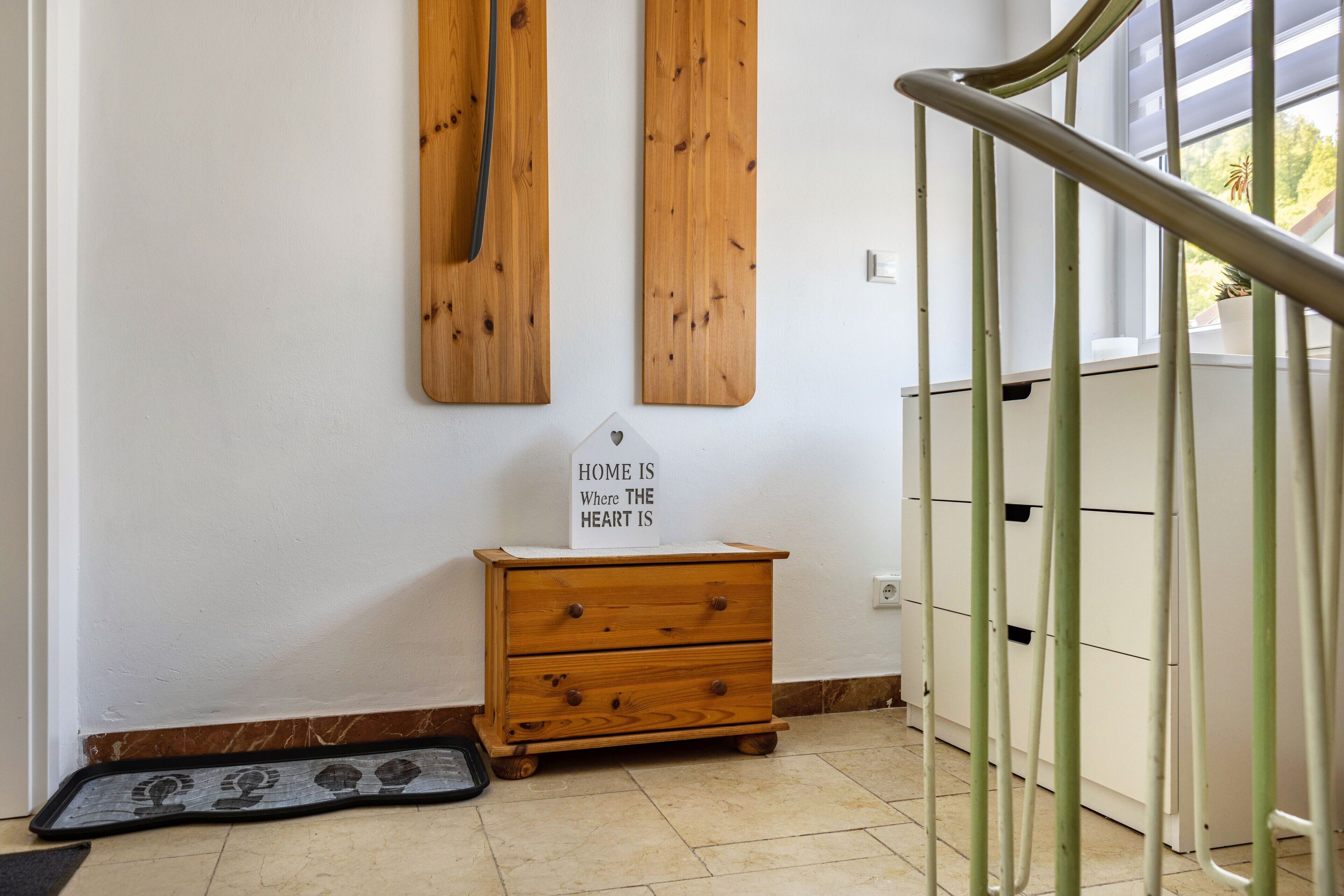 Une commode en bois avec une enseigne, un panneau mural en bois et une rambarde en métal.