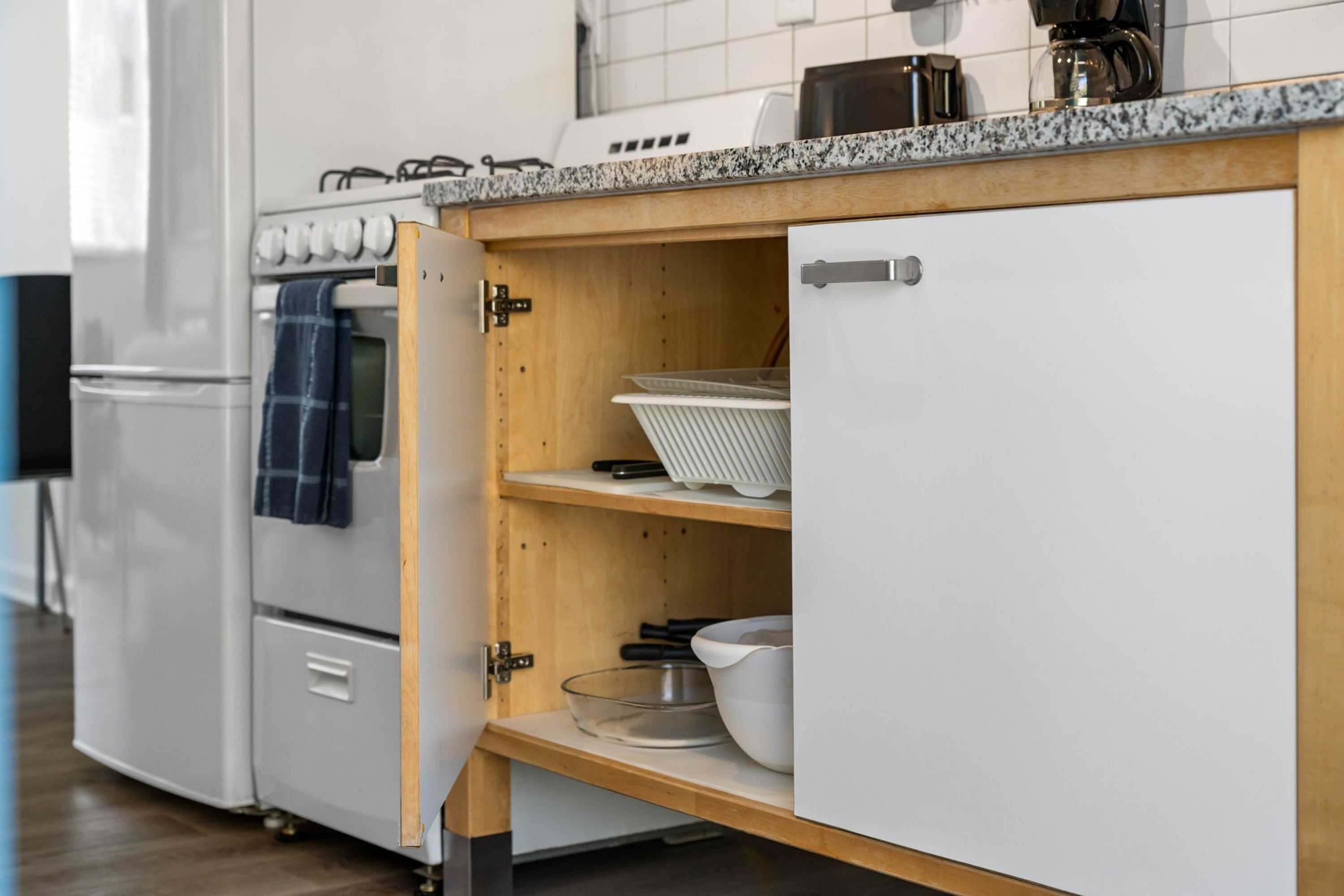 A kitchen with white cabinets, a wooden countertop, and a built-in oven.
