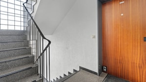 Eine Treppe mit Metallgeländern, die zu einer Holztür führt.
