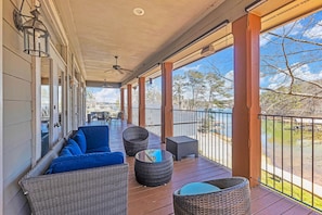 A covered porch with wicker furniture, a ceiling fan, and a view of a body of water. - Sailor's Cove at Lake Martin, 3 bedrooms, 2.5 baths, pets ok! (Dadeville)