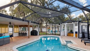 A covered outdoor swimming pool with a built-in seating area and a patio. - Sunny Terrace • Pool  Hot Tub • B-Ball CT•  Near Busch Gardens & USF • Sleeps 10 (Tampa)