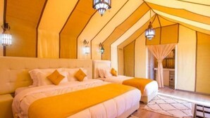 Een slaapkamer met twee bedden, een groot raam en een balkon.