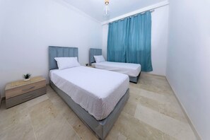 Ein Schlafzimmer mit zwei Betten, einem Nachttisch und einer Kommode.