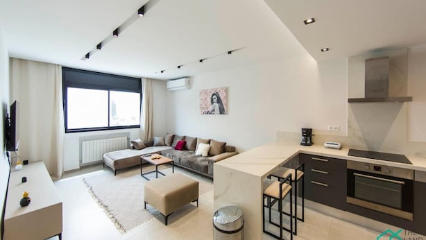 A modern apartment with a living area, kitchenette, and a large window. - Sunset 204 Luxury 2bds with Gym (Tunis)