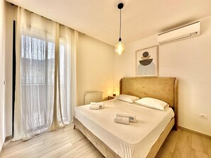 A hotel room with a bed, a radiator, a hanging light fixture, and a window with sheer curtains. - A22 Cozy and central at La Marsa (Marsa)
