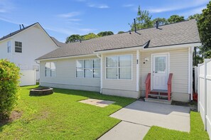 Een gelijkvloers huis met een veranda, een kleine voortuin en een garage.