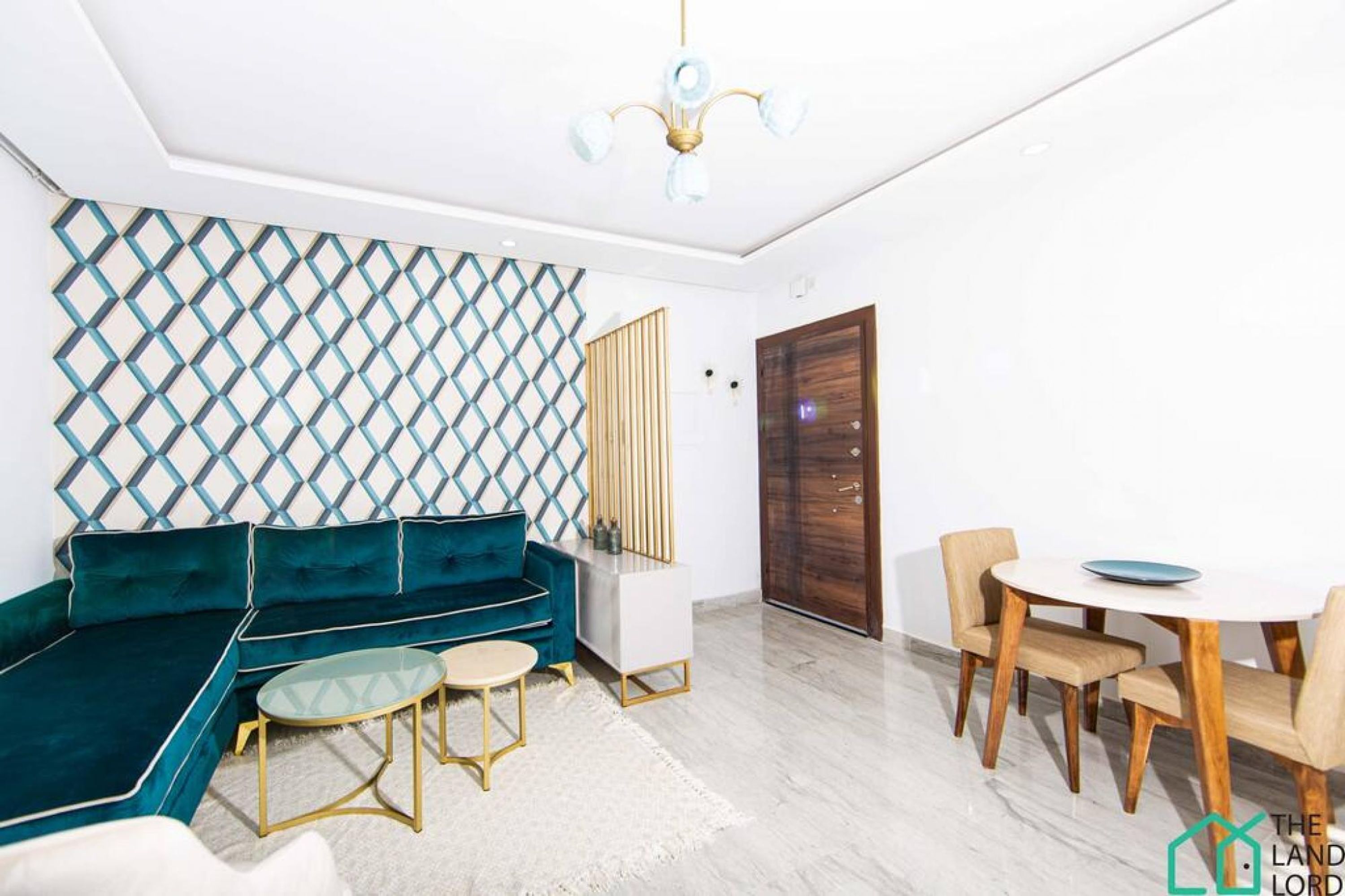 A modern living room with a teal sectional sofa, a glass coffee table, and a dining area with wooden chairs and a white table.